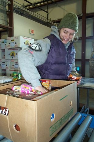 AmeriCorps member packing food in a box